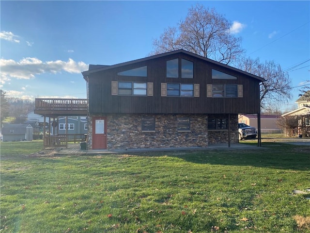 back of house with a wooden deck, a yard, and a carport