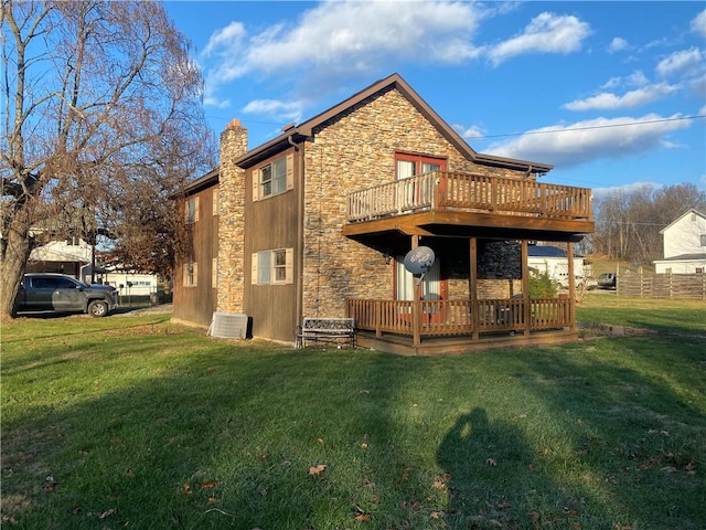 rear view of house featuring central AC, a deck, and a lawn