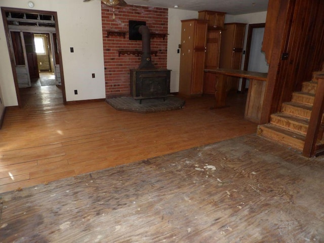 unfurnished living room featuring a wood stove and hardwood / wood-style flooring