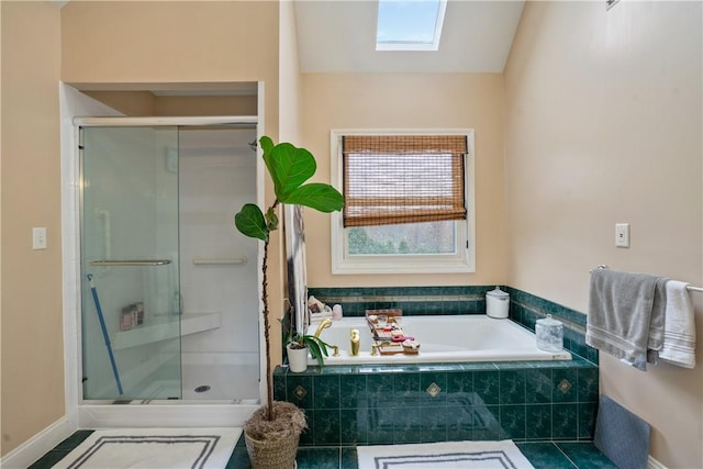 bathroom featuring tile patterned floors, a skylight, and shower with separate bathtub