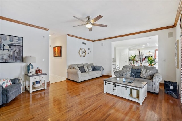 living room with ceiling fan, wood-type flooring, and ornamental molding