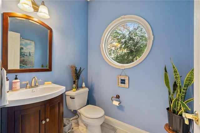 bathroom with toilet, vanity, and tile patterned floors