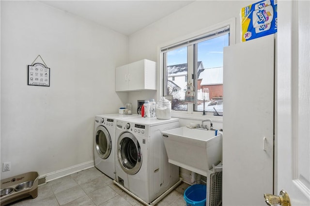 laundry room with washer and clothes dryer, light tile patterned flooring, cabinets, and sink