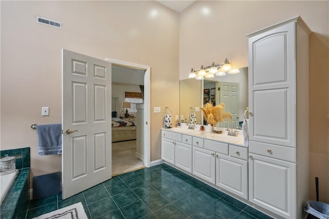 bathroom with a bathing tub, tile patterned flooring, vanity, and a towering ceiling