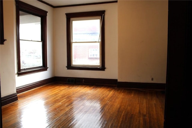 unfurnished room with hardwood / wood-style floors and crown molding