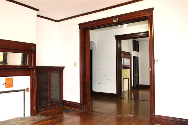 empty room featuring crown molding and dark wood-type flooring