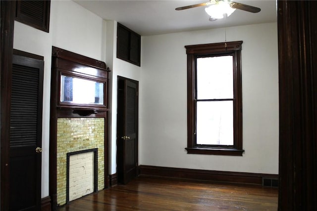 unfurnished bedroom with multiple windows, ceiling fan, and dark hardwood / wood-style flooring