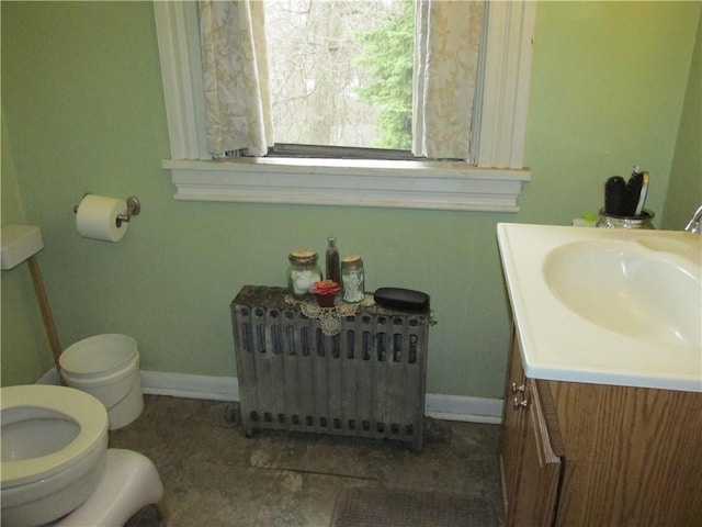 bathroom with vanity, toilet, and radiator heating unit