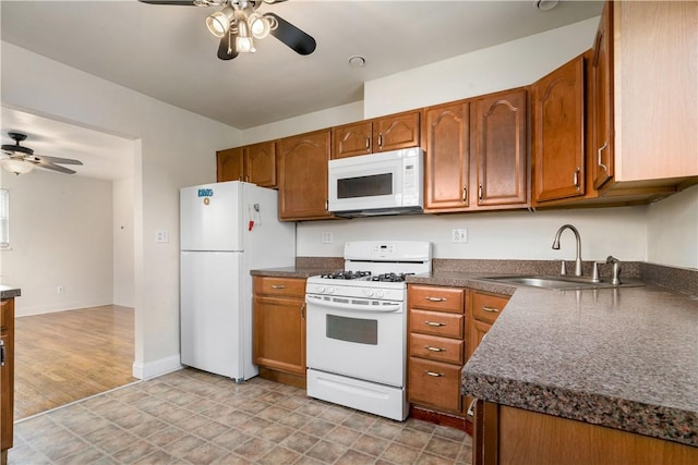 kitchen with ceiling fan, sink, white appliances, and light wood-type flooring