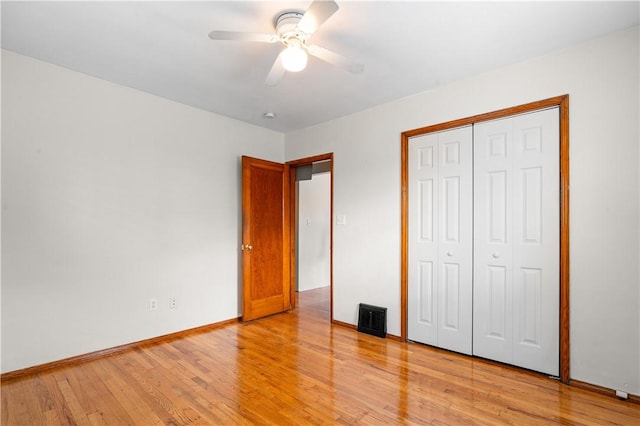 unfurnished bedroom with ceiling fan, a closet, and light wood-type flooring