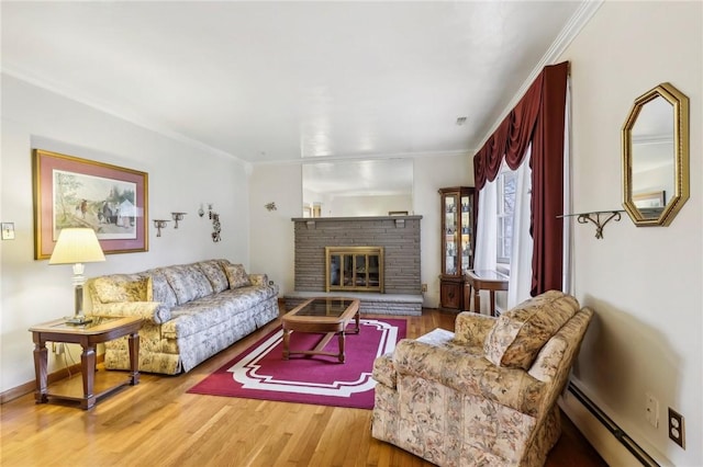 living room featuring a brick fireplace, ornamental molding, wood-type flooring, and a baseboard heating unit