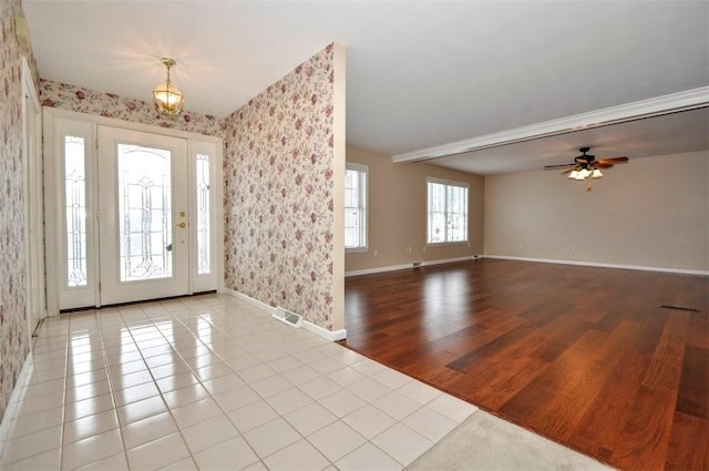 foyer entrance featuring ceiling fan, a healthy amount of sunlight, and light wood-type flooring