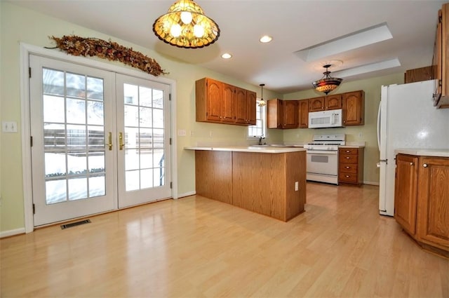 kitchen with plenty of natural light, white appliances, light wood-type flooring, french doors, and hanging light fixtures