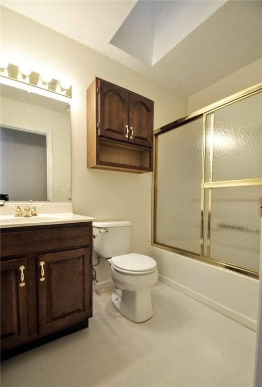 full bathroom featuring combined bath / shower with glass door, vanity, and toilet