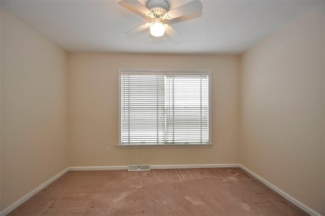 carpeted spare room featuring ceiling fan