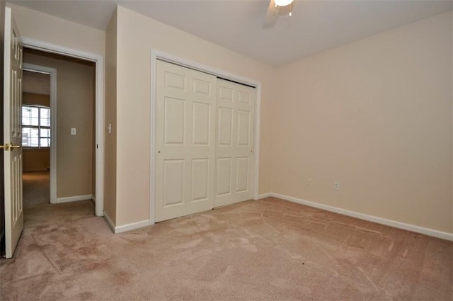 unfurnished bedroom featuring light carpet, ceiling fan, and a closet