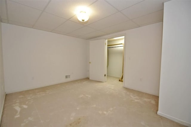 unfurnished bedroom featuring light carpet, a closet, and a drop ceiling