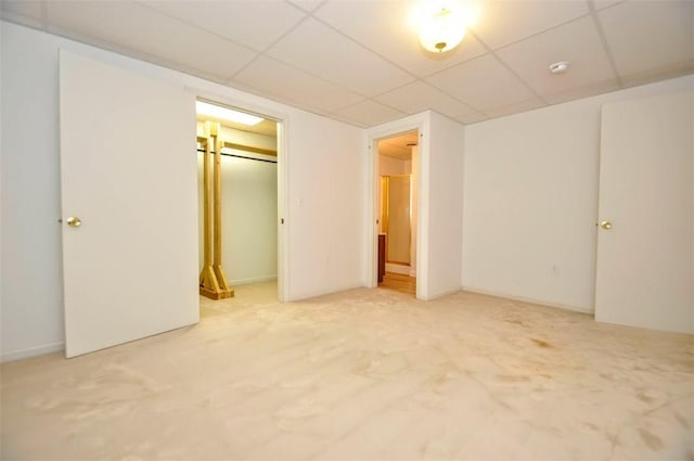 unfurnished bedroom featuring carpet floors, a closet, and a drop ceiling