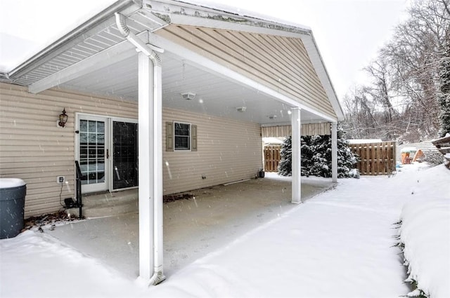 snow covered patio featuring a carport