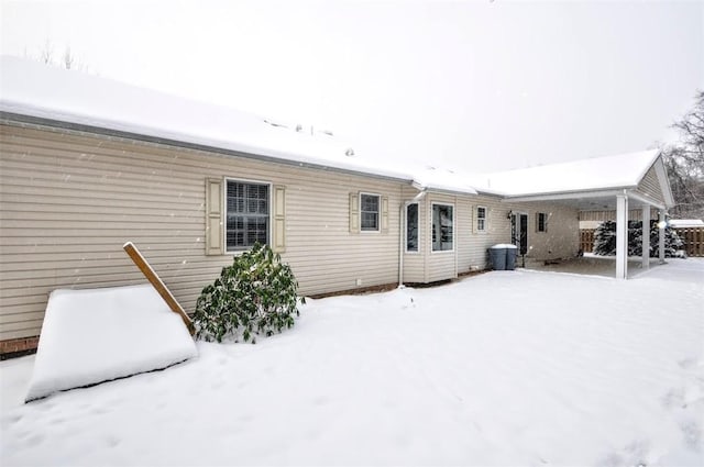 view of snow covered rear of property