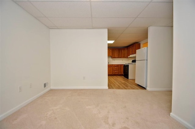 kitchen with light colored carpet, a paneled ceiling, white refrigerator, and range