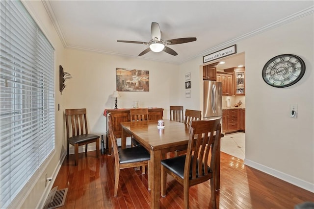 dining room with crown molding, hardwood / wood-style floors, and ceiling fan