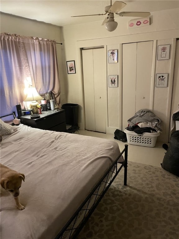 bedroom with ceiling fan, carpet, and two closets