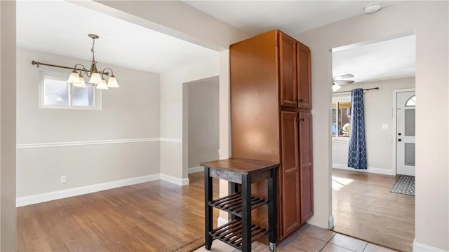 hall featuring a chandelier and light hardwood / wood-style floors