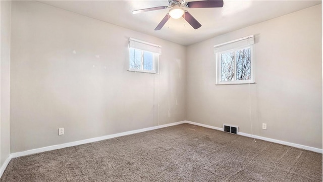 carpeted empty room featuring ceiling fan and a wealth of natural light