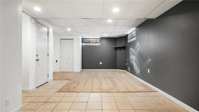 basement with light tile patterned floors and a drop ceiling