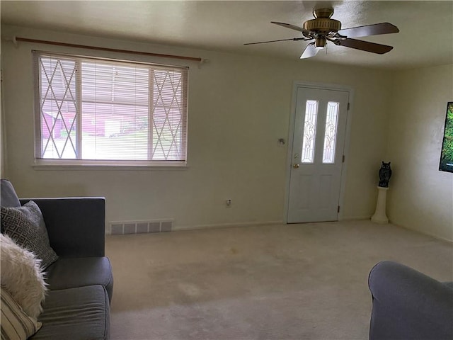 carpeted living room featuring ceiling fan and plenty of natural light