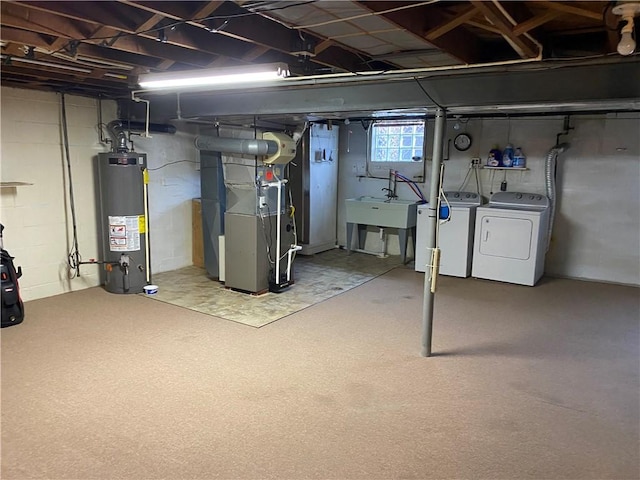 basement with washing machine and clothes dryer, heating unit, sink, and gas water heater