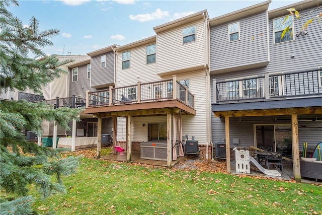 back of house with a lawn, a patio area, and central AC