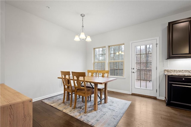 dining area featuring dark wood-type flooring and a notable chandelier