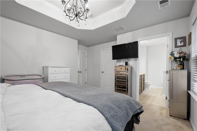 bedroom featuring a raised ceiling, a notable chandelier, light colored carpet, and connected bathroom