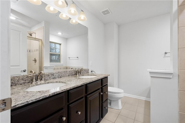 bathroom featuring tile patterned floors, vanity, toilet, and a shower with shower door