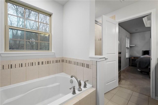 bathroom featuring tiled bath and tile patterned flooring