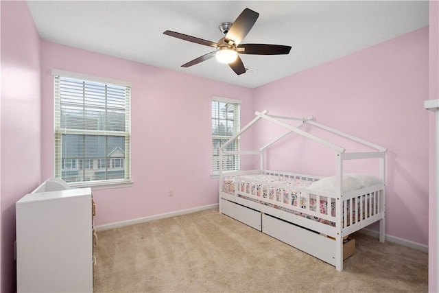 unfurnished bedroom featuring ceiling fan, light carpet, and multiple windows