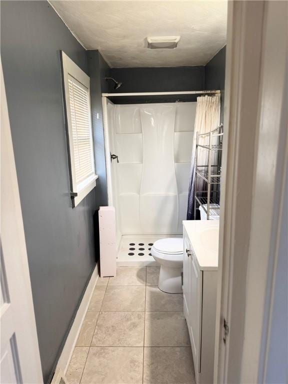 bathroom featuring a shower with curtain, vanity, toilet, and tile patterned floors