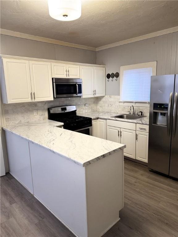 kitchen featuring white cabinetry, sink, tasteful backsplash, dark hardwood / wood-style flooring, and appliances with stainless steel finishes