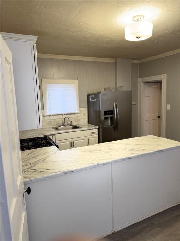 kitchen with dark wood-type flooring, black range, sink, stainless steel refrigerator with ice dispenser, and white cabinetry