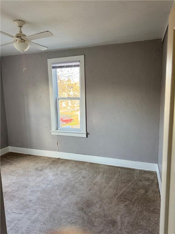 unfurnished room with carpet floors and ceiling fan