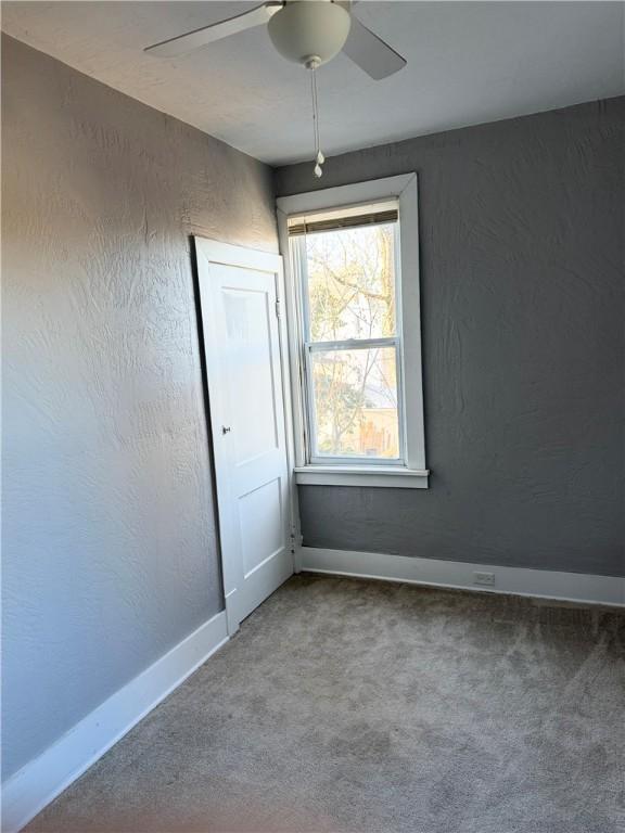 empty room with carpet flooring and ceiling fan