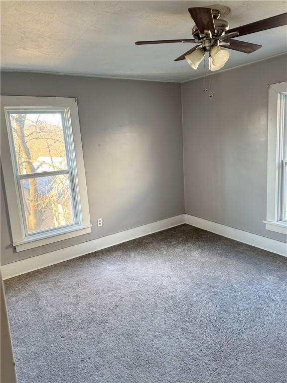 spare room with carpet and ceiling fan