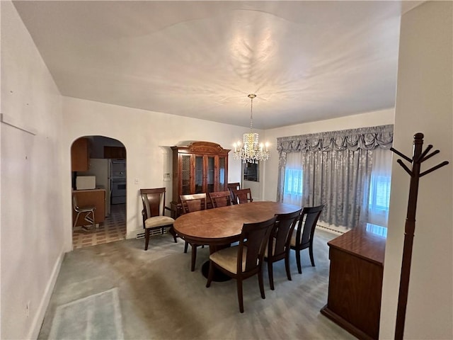 dining area with carpet floors and an inviting chandelier