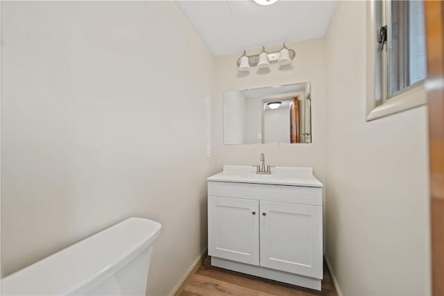 bathroom featuring hardwood / wood-style flooring, vanity, and toilet