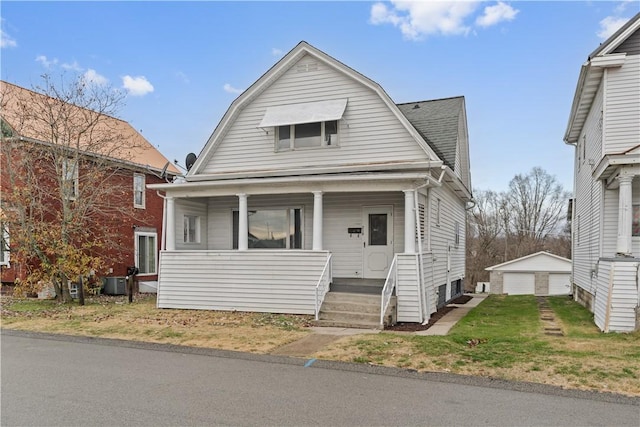 bungalow-style house featuring central air condition unit, covered porch, an outdoor structure, and a garage