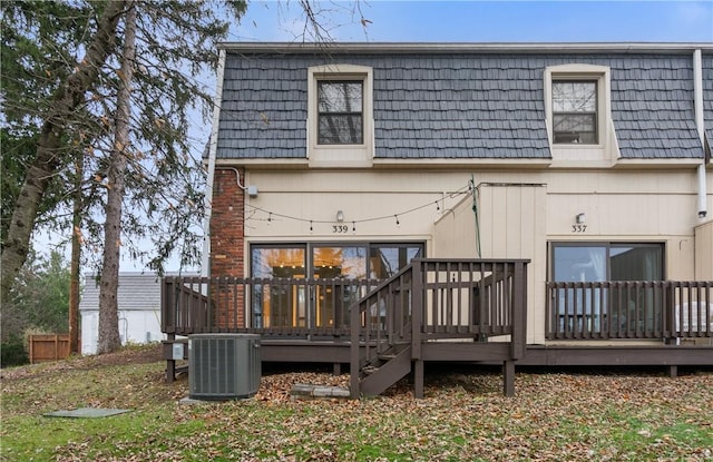 back of property with a deck, mansard roof, and cooling unit