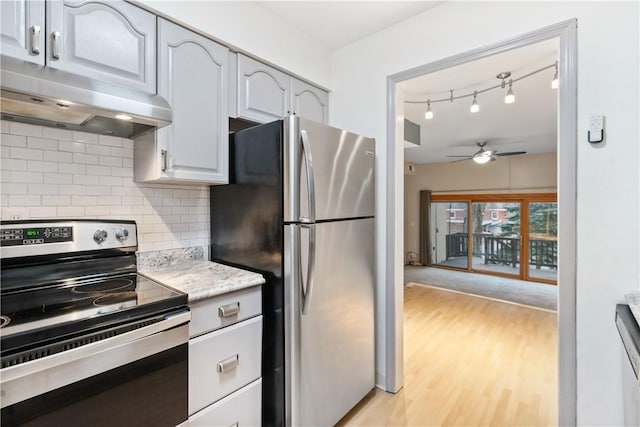 kitchen with light wood finished floors, tasteful backsplash, ceiling fan, appliances with stainless steel finishes, and under cabinet range hood