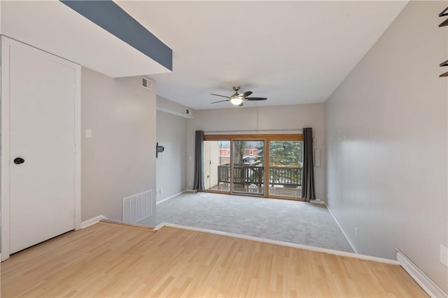 unfurnished room featuring ceiling fan, wood finished floors, visible vents, and baseboards